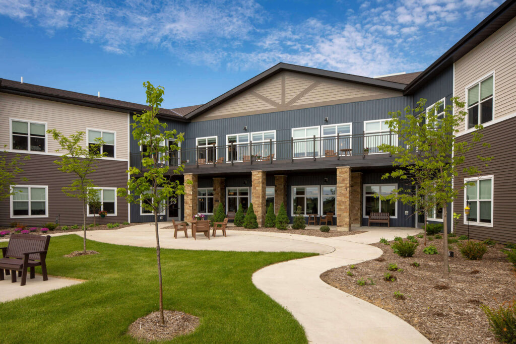 Modern residential housing complex with landscaped courtyard and outdoor seating.