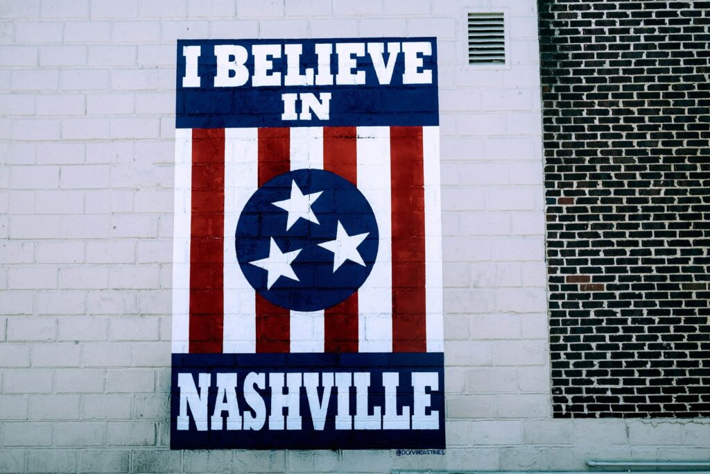 Mural reading "I Believe in Nashville" painted on brick wall.